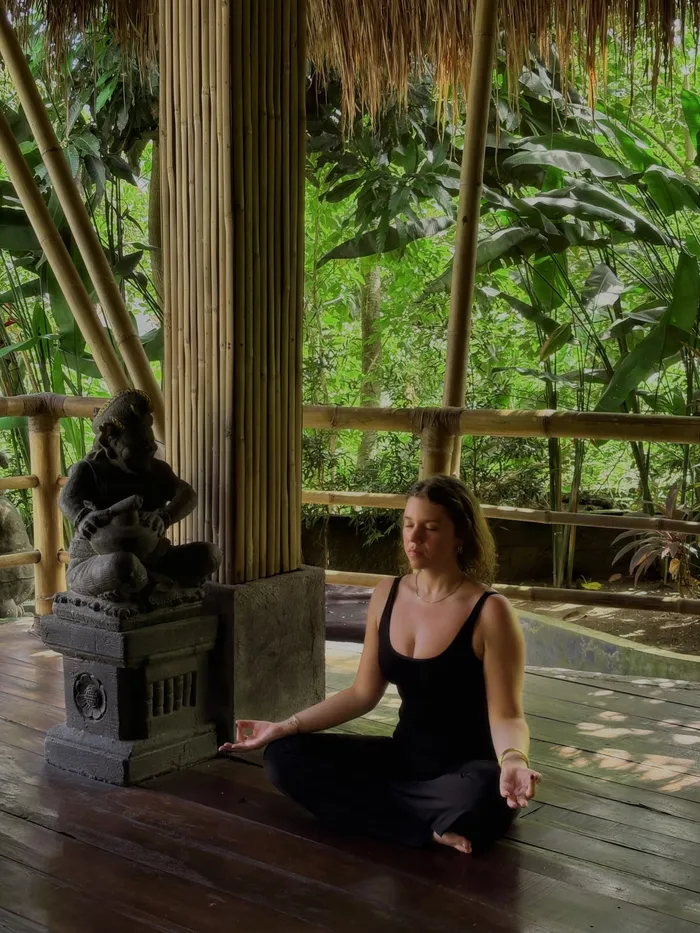 A guest meditating at a surf and yoga retreat